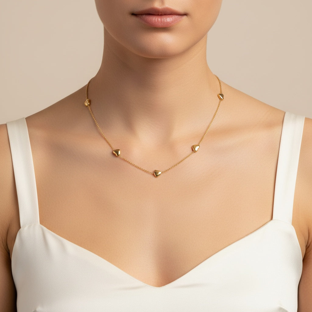 Collier NAYA de Margeli avec pendentif en métal doré et chaîne fine, porté sur un fond neutre.